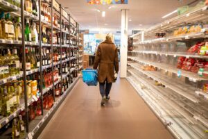 Person walking down a supermarket aisle